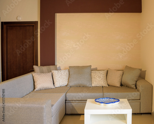 Fototapeta Naklejka Na Ścianę i Meble -  Plush seating arrangement with blank wall shot as a background for artists to insert their art frames to use in advertising. 