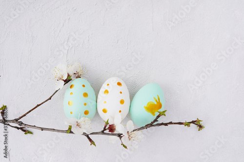 Easter eggs and spring flowers on grey background with a copy space photo