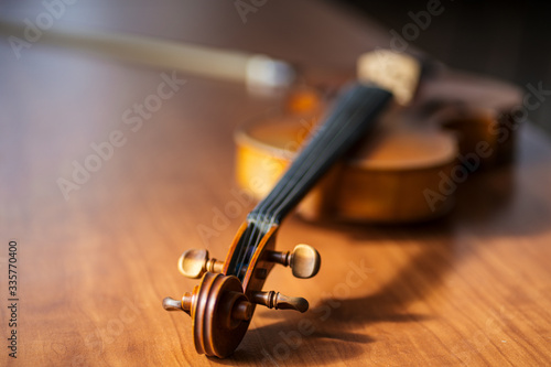 close-up photo of musical instrument violin lying on wooden table. classical music instrument, music concept photo