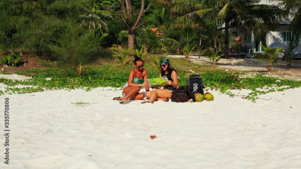 Tourist women watching local guide map of vacation destinations and exotic beaches on tropical island in Indonesia Tourist women watching local guide map of vacation destinations and exotic beaches on tropical island in Indonesia