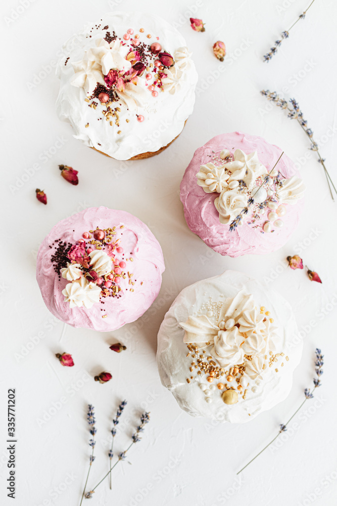 Naklejka premium Glazed easter cake decorated with flowers on white textured background. Happy Easter Holidays