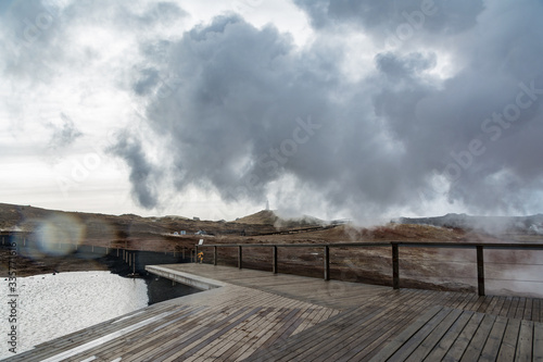 Geothermal area in Iceland. Powerful steam jet above the ground. A smoking geyser on a background of yellow clay and a cloudy sky. Reykjanes Peninsula © Ольга Страхова