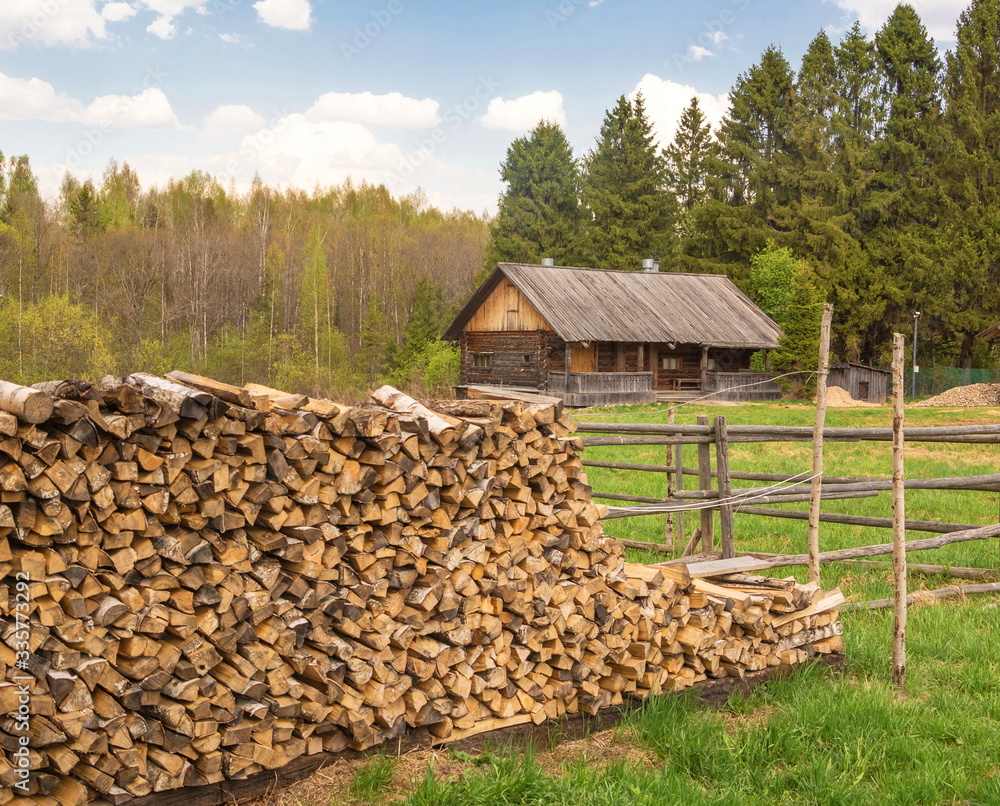 Woodpile of firewood in  yard of  rural log cabin