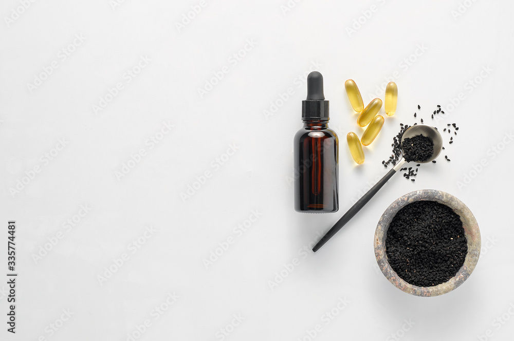 Caraway seeds in a wooden spoon with essential oil in glass bottle
