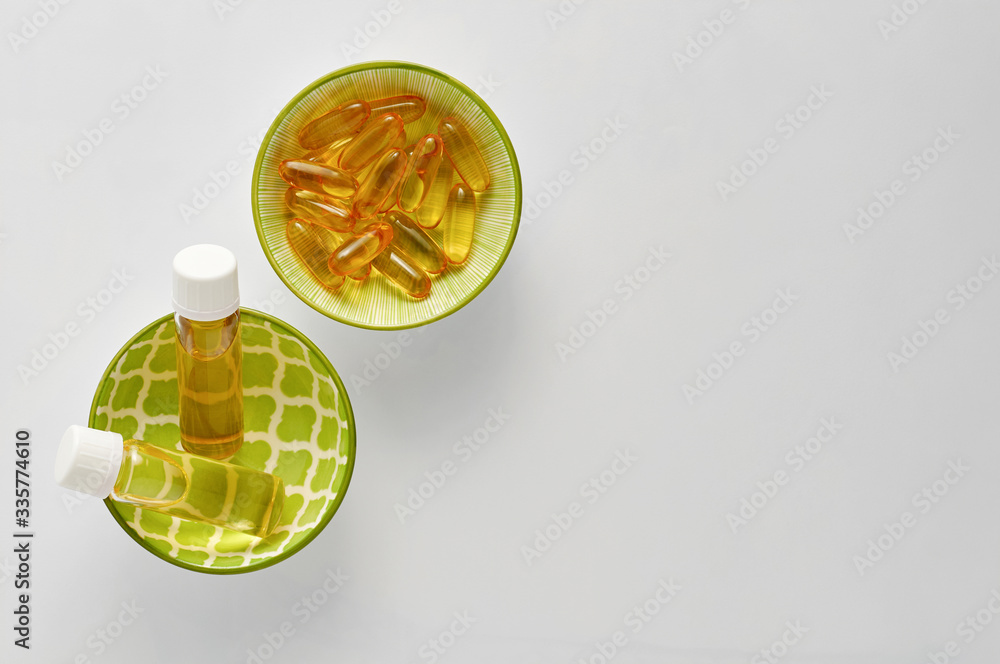 Bottle and pills of black cumin seeds essential oil Nigella Sativa on white background