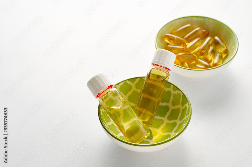 Bottle and pills of black cumin seeds essential oil Nigella Sativa on white background