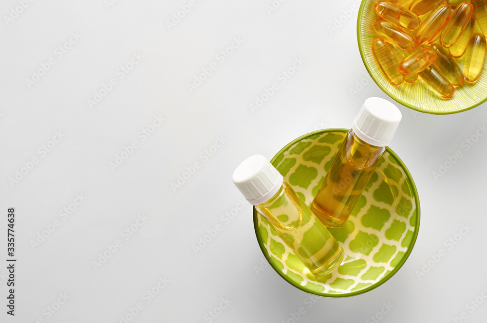Bottle and pills of black cumin seeds essential oil Nigella Sativa on white background