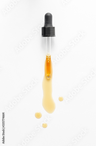 Obraz na płótnie Pipette dropping essential black cumin seeds Nigella Sativa on white background w salonie