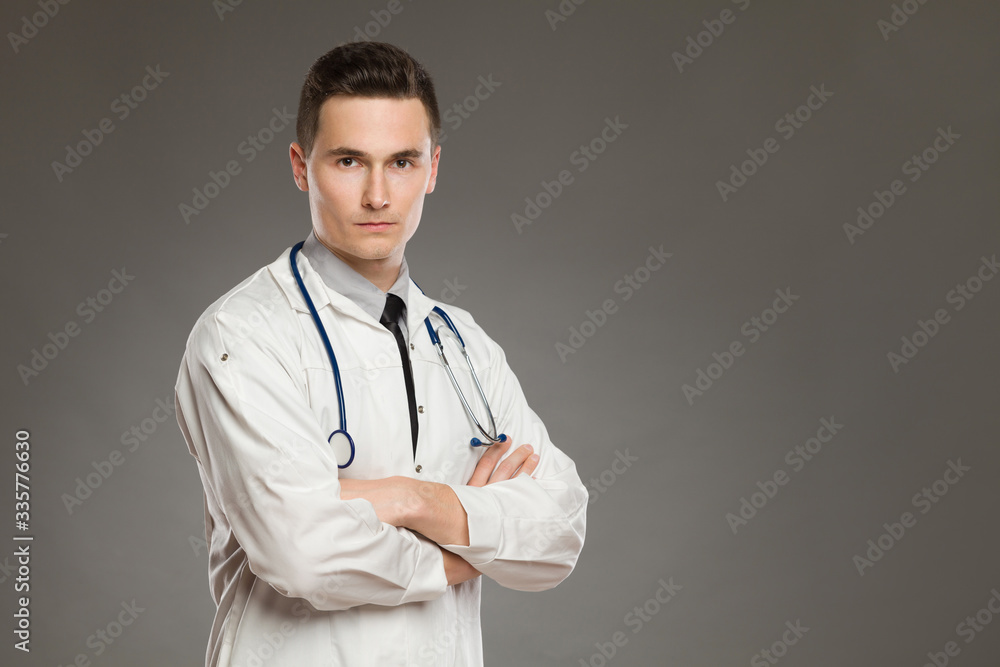 Serious male doctor is posing with arms crossed. Serious male doctor is posing with arms crossed.