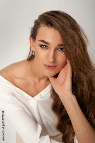 Beautiful long-haired brunette at ease posing in the studio.