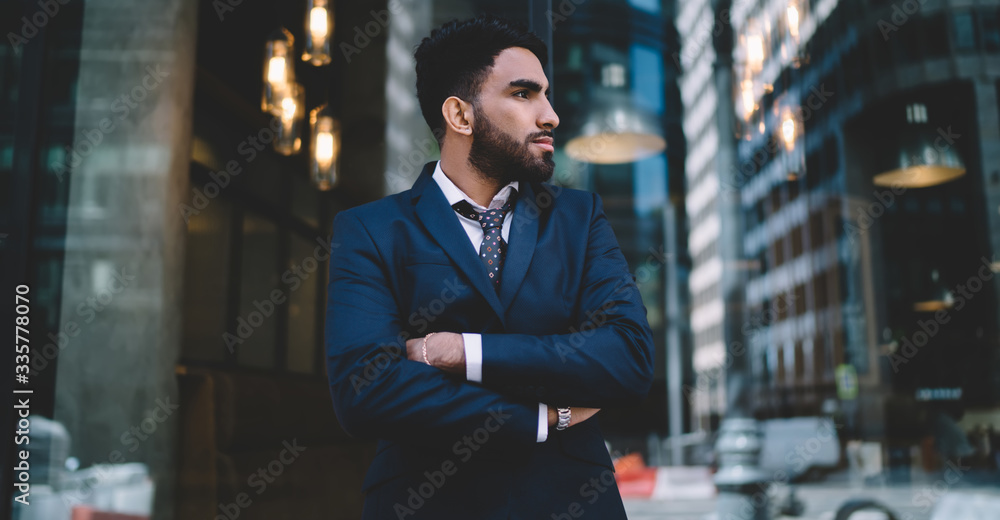 Pensive stylish ethnic manager contemplating work in office