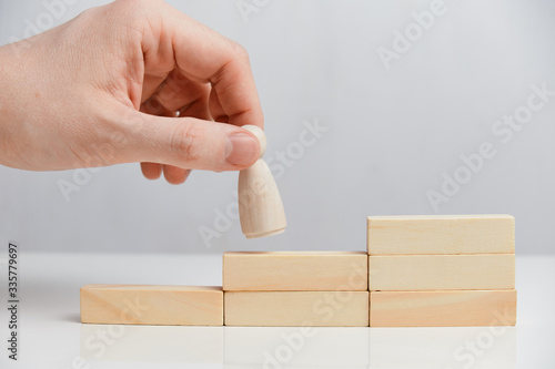 Career growth concept. Hand holds wooden blocks on a white background.