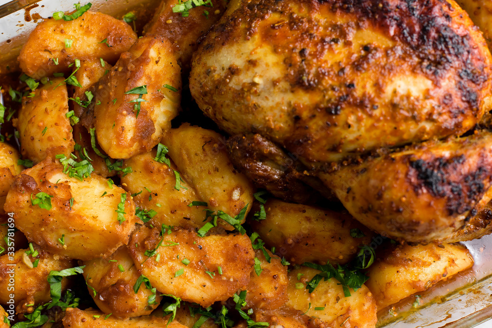 Baked whole chicken with potatoes and herbs in a rustic style. Top view, side view on a light background. Close-up and medium plan. Space for text. Baked whole chicken with potatoes and herbs in a rustic style. Top view, side view on a light background. Close-up and medium plan. Space for text.