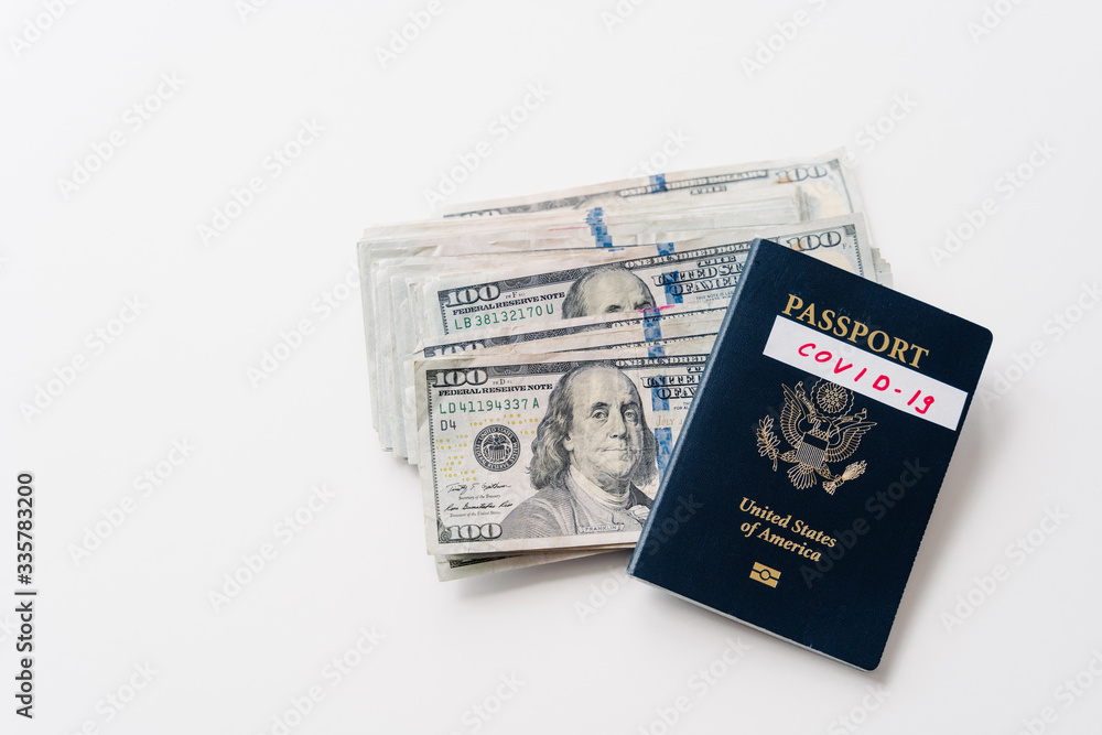 National passport with inscription Covid-19 and money banknotes on white background. Travel restrictions and quarantine. Coronavirus and traveling concept National passport with inscription Covid-19 and money banknotes on white background. Travel restrictions and quarantine. Coronavirus and traveling concept