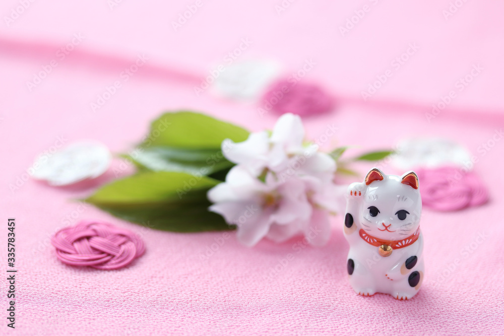商売繁盛の招き猫と桜の花（オオシマザクラ）