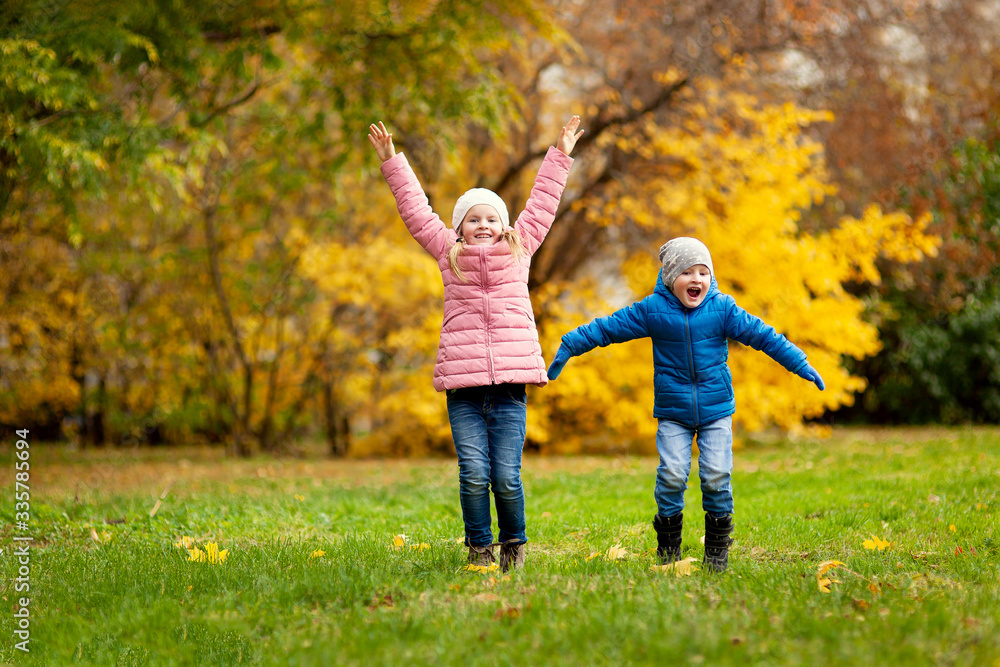 Adorable little girl and boy outdoors at beautiful autumn day