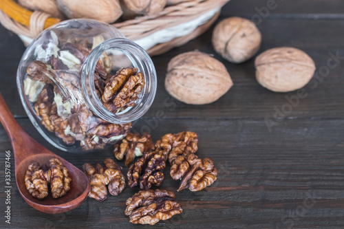 peeled walnuts in a glass jar close-up. walnuts on the table and in a wooden spoon. © Nataliya