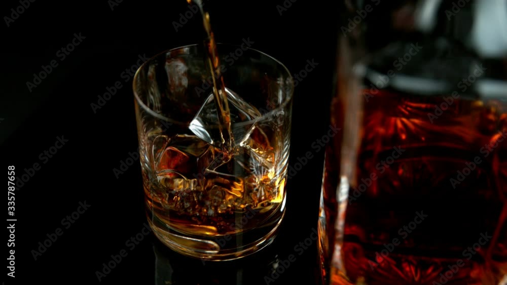 Super slow motion of pouring whiskey or rum with slide motion. Filmed on high speed cinema camera, 1000fps Super slow motion of pouring whiskey or rum with slide motion. Filmed on high speed cinema camera, 1000fps