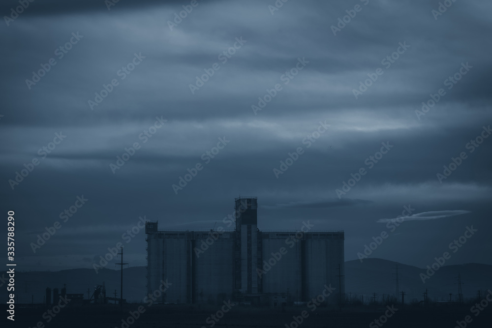 Concrete industrial building at night with moonlight, dark sky and mystic atmosphere