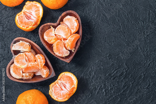 tangerine slices in a wooden bowl top view. background with tangerine slices. tangerines and copy space.