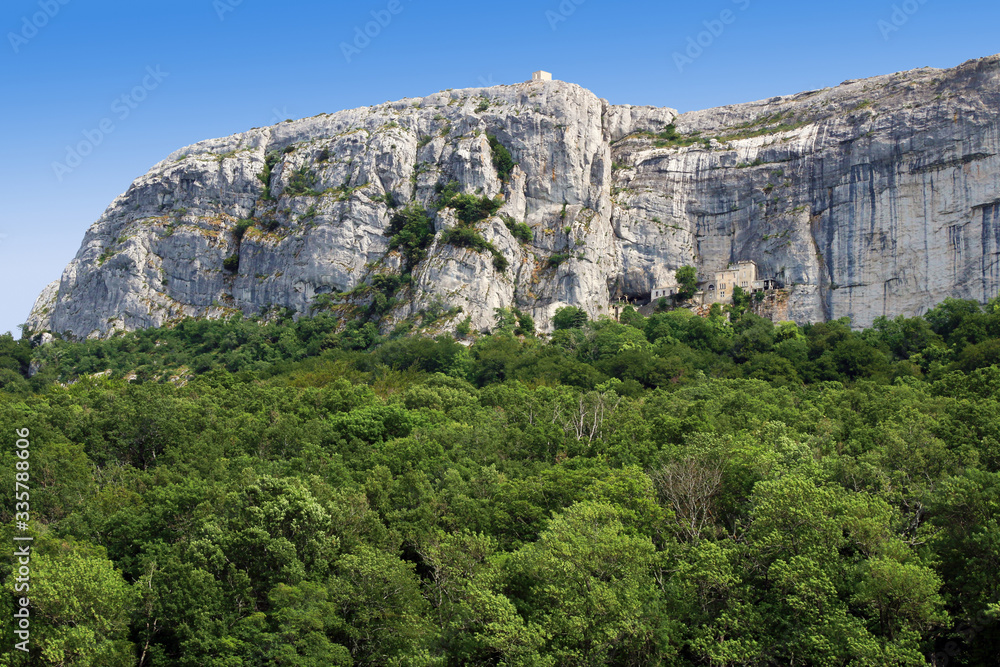 Sanctuaire de la Sainte-Baume installé dans une grotte au pied de la falaise, au dessus de la forêt domaniale.