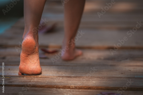 Close up barefoot girl posing walking relax on walkway bridge wood beach with sunlight shine