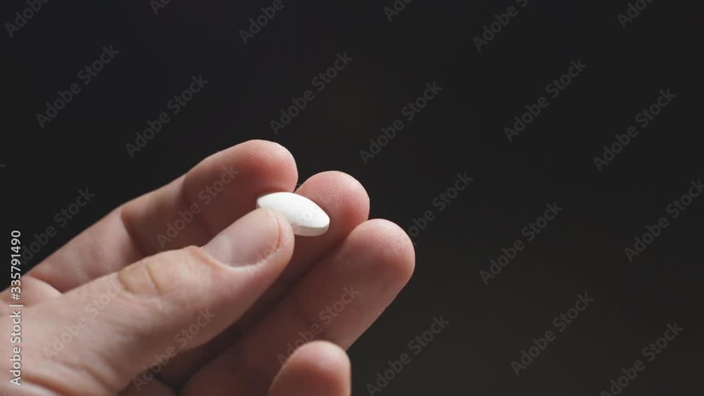 close-up of a white tablet in a man's hand on a dark background. close-up of a white tablet in a man's hand on a dark background.