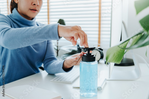 Woman hands using alcohol gel clean wash hand sanitizer anti virus bacteria and working from home