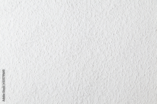 Uniform white roughly textured wall 