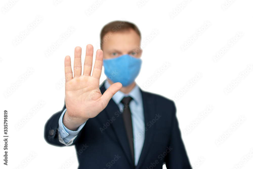 Young businessman with medical mask is showing stop gesture Young businessman with medical mask is showing stop gesture