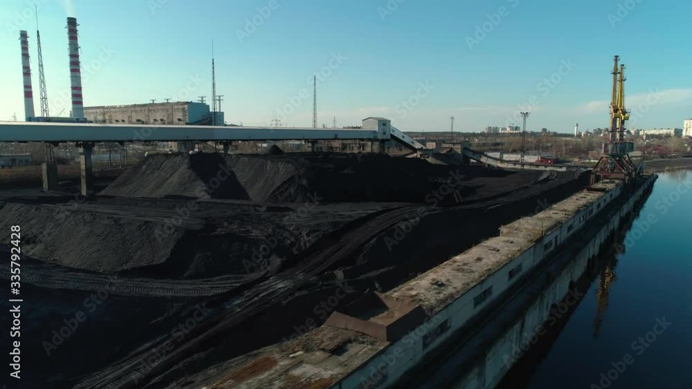 Aerial view of open coal warehouse near river with crane and conveyor Aerial view of open coal warehouse near river with crane and conveyor