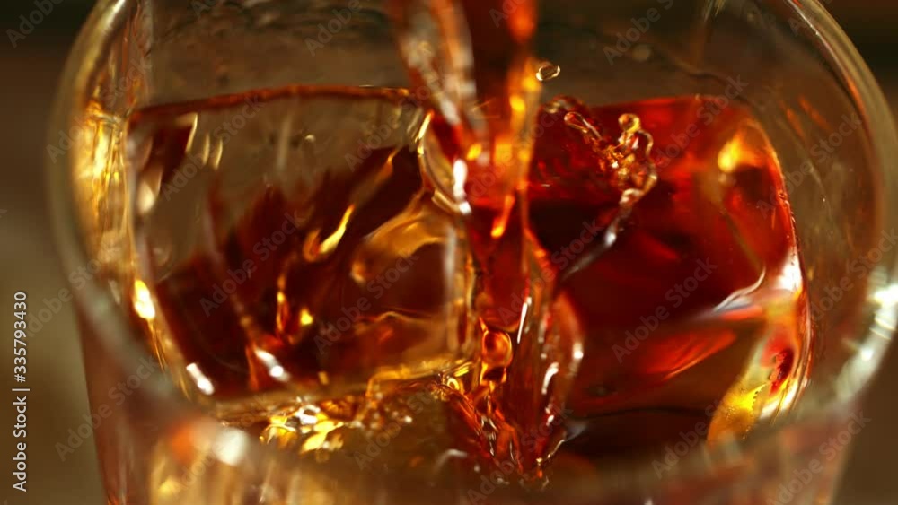 Super slow motion of pouring whiskey in super macro shot. Filmed on high speed cinema camera, 1000fps Super slow motion of pouring whiskey in super macro shot. Filmed on high speed cinema camera, 1000fps