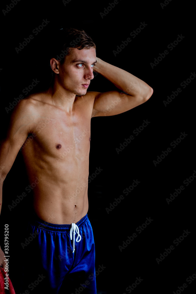 Shirtless muscles guy prepare for wokout against dark background Shirtless muscles guy prepare for wokout against dark background