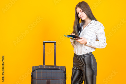 Girl next to a travel suitc...