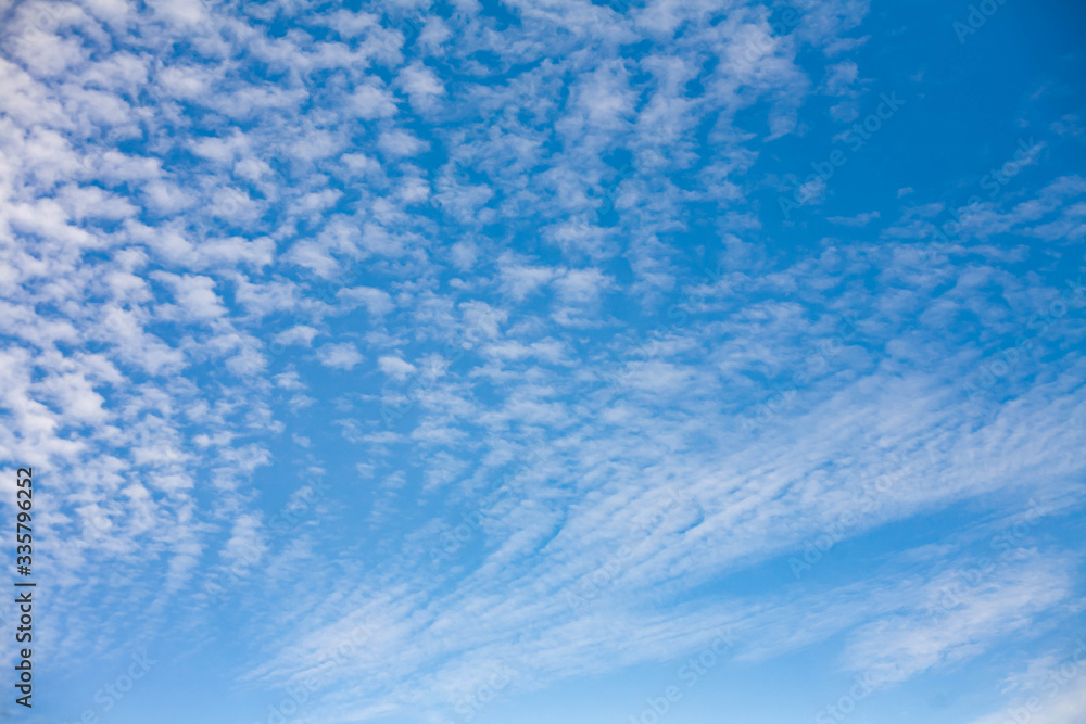 Beautiful landscape with porous white clouds on blue sky.