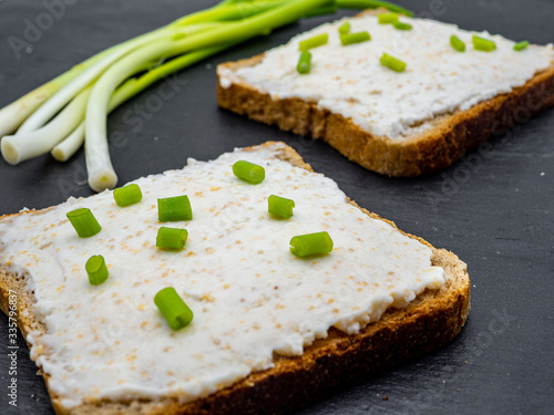 fish roe paste spread on bread slices and green onion on slate breakfast snack concept