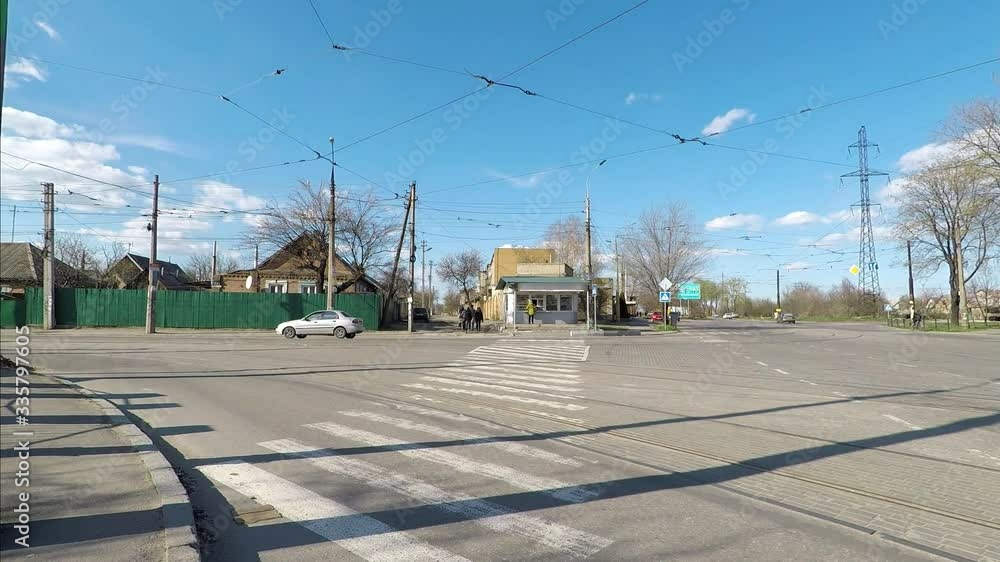traffic through a pedestrian crossing of the street on a clear sunny day with blue skies and clouds. empty road and houses. traffic through a pedestrian crossing of the street on a clear sunny day with blue skies and clouds. empty road and houses.