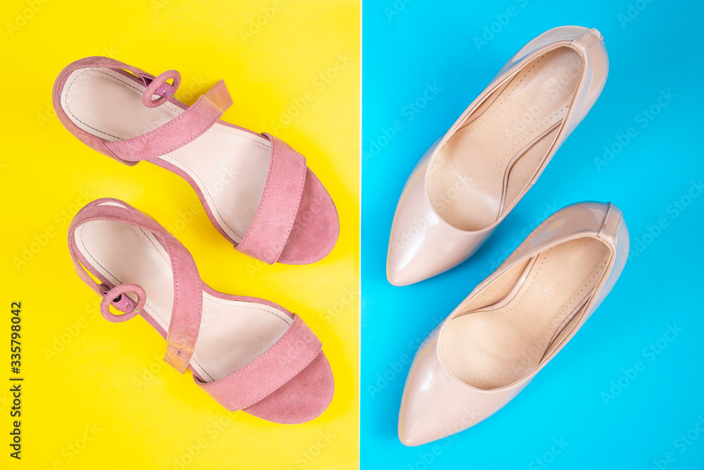 Women's pink summer sandals and pumps on a yellow and blue background. Fashionable shoes for young girls. Top view. Women's pink summer sandals and pumps on a yellow and blue background. Fashionable shoes for young girls. Top view.