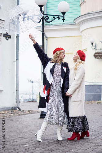 Two beautiful fashionable women in retro style is on the street.. © Demian