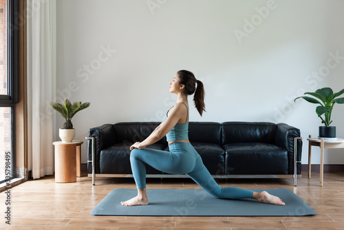 A young Asian woman doing yoga at home