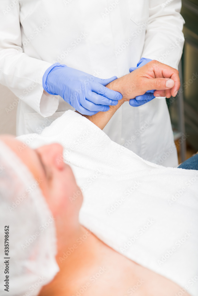 Doctor holds hand of man and counts his pulse Doctor holds hand of man and counts his pulse