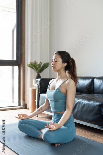 A young Asian woman doing yoga at home Free Download A young Asian woman doing yoga at home - GFXLoad