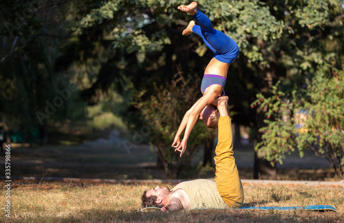 Acro yoga couple practising shoulder stand pose