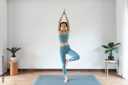 A young Asian woman doing yoga at home