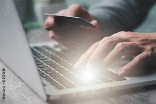 businessman work from home and shopping online and enters a credit card number into a laptop to pay online. Online shopping, lifestyle technology. Close-up