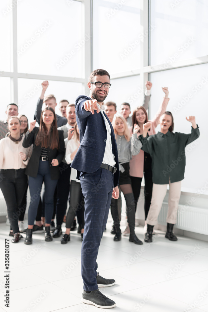Fototapeta premium in full growth. smiling businessman pointing at you.