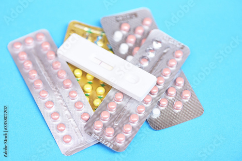Contraception pills and Pregnancy test on blue background - Birth control contraceptive means prevent pregnancy