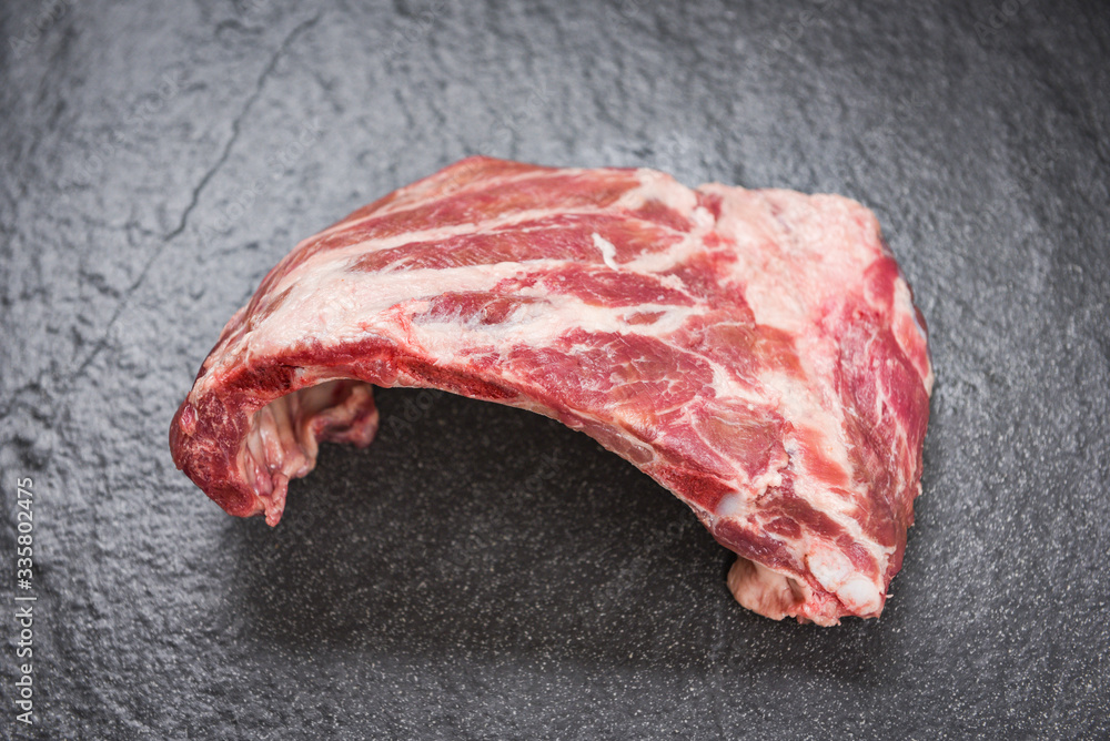 Raw pork ribs meat on black plate background / Fresh pork spare ribs for cooking roasted or grilled Pork bone