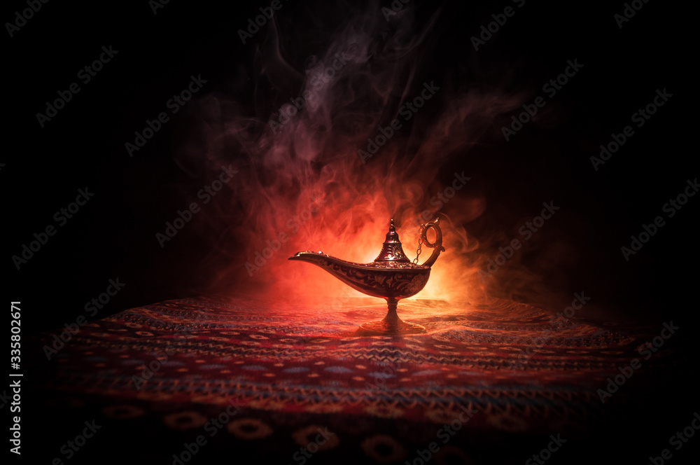 Lamp of wishes concept. Antique Aladdin arabian nights genie style oil lamp  with soft light white smoke, Dark background. Stock-Foto | Adobe Stock