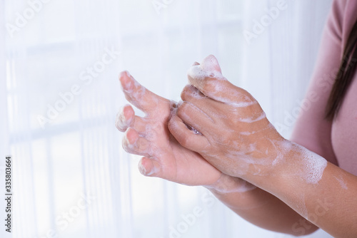 Closeup woman washing hands with soap on white background for prevention Coronavirus disease (COVID-19). Healthcare and disinfection concept.